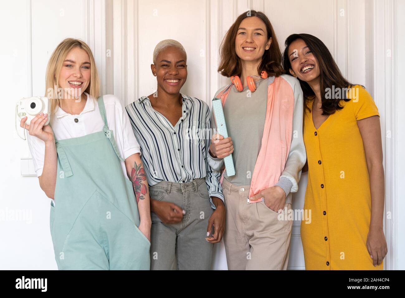 Ritratto di quattro donne sorridente in piedi a fianco a fianco Foto Stock