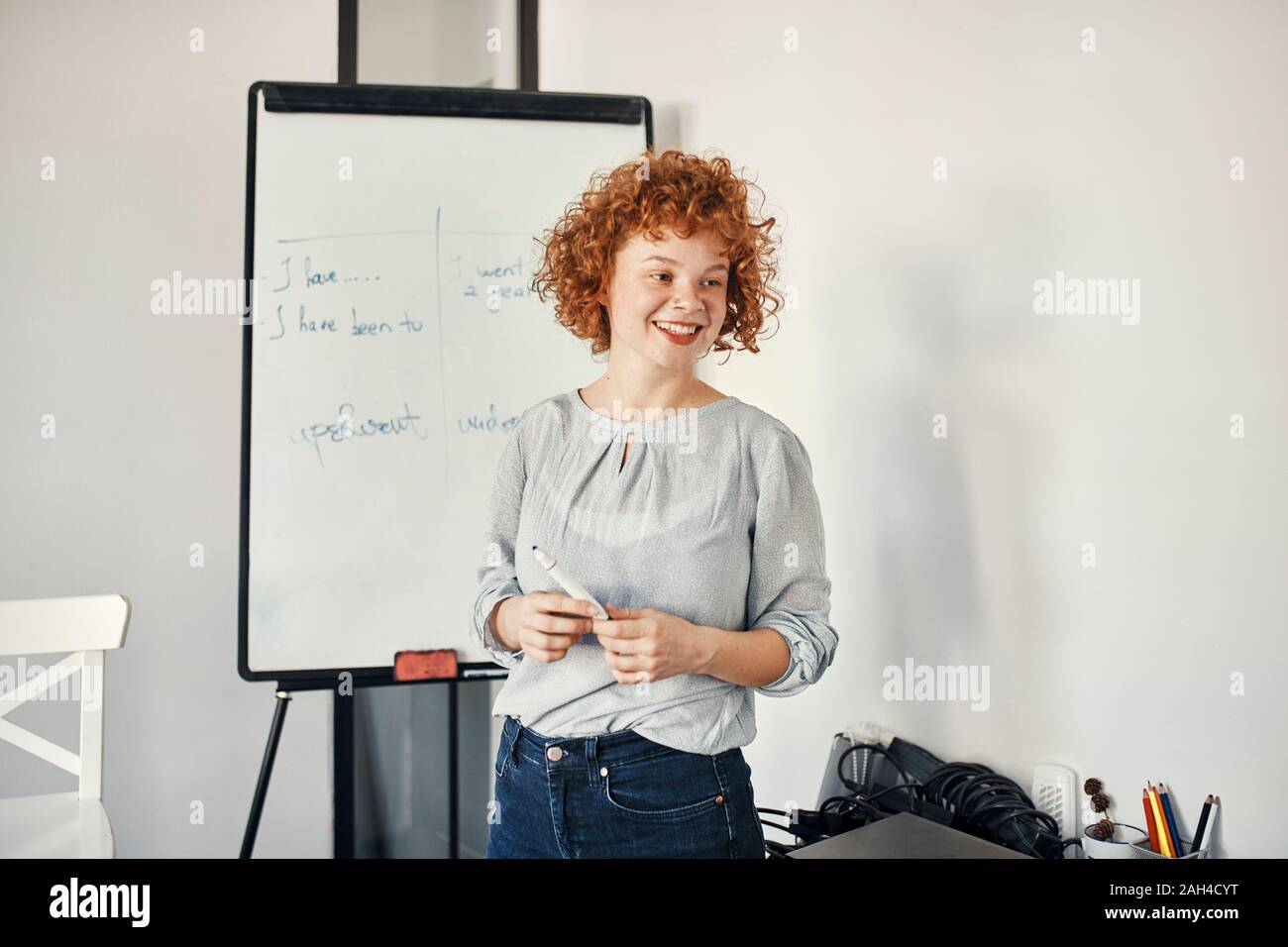 Sorridente imprenditrice portando una presentazione alla lavagna a fogli mobili in sala conferenze Foto Stock