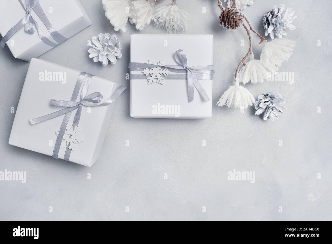 Progettazione di frontiera un Natale biglietto di auguri con il Natale regalo, coni, i fiocchi di neve con posto per il vostro testo. Decorazioni su un cemento bianco sullo sfondo Foto Stock