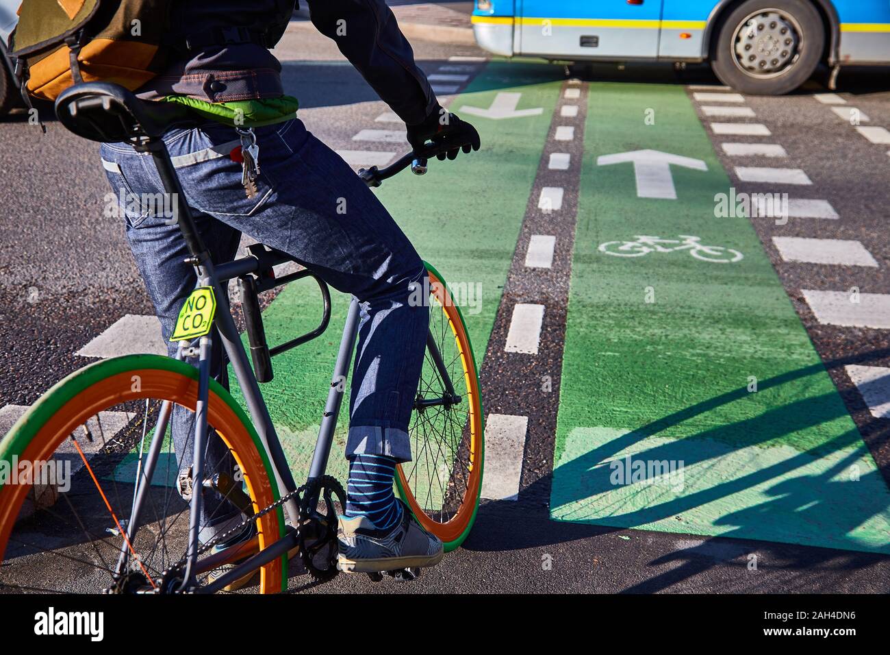 Un ciclista in città va su un attraversamento pedonale. Eco-friendly modalità di trasporto. Bicicletta con velocità fissa Foto Stock