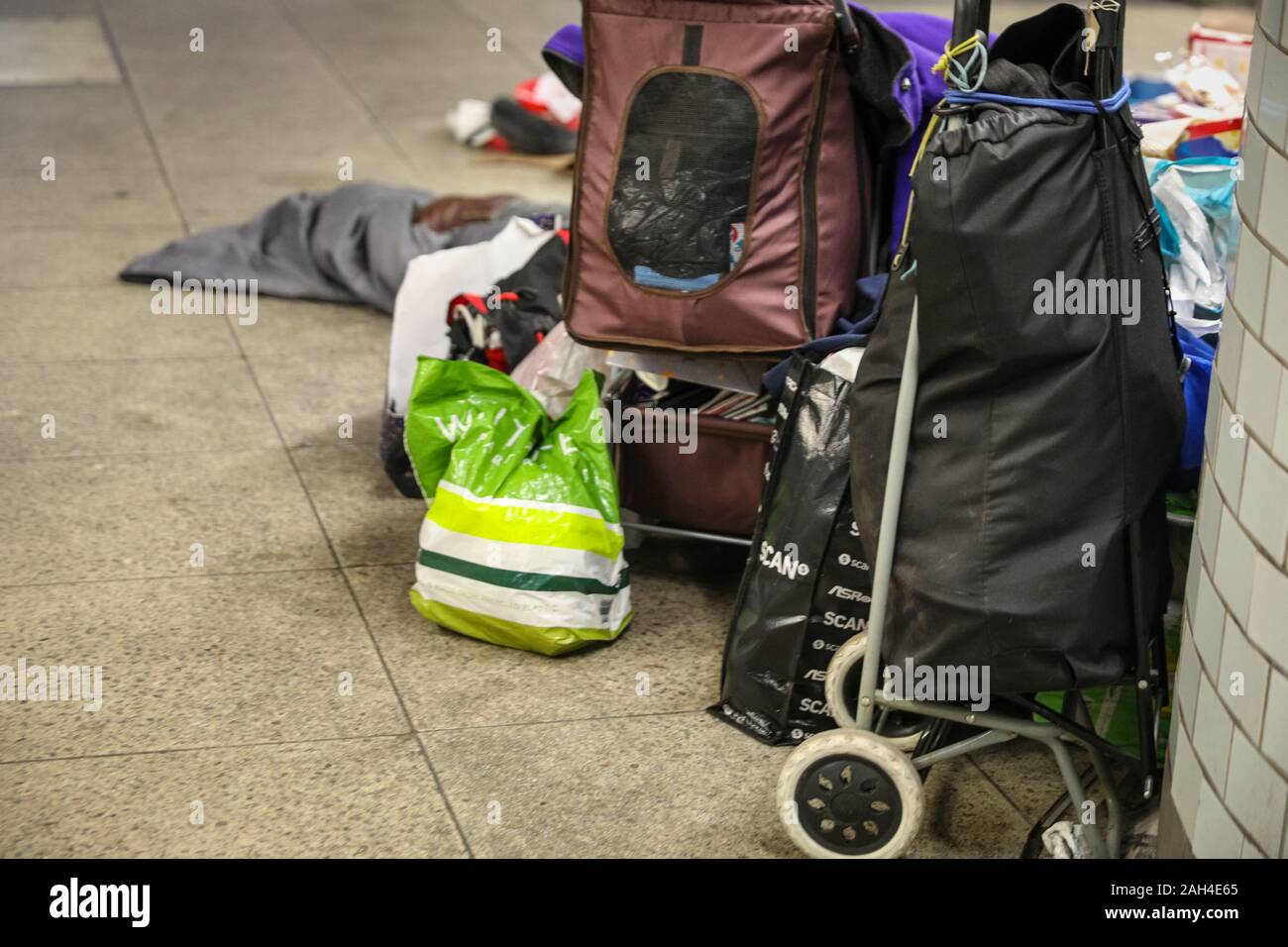 Central London, Londra, 24 dic 2019. Una persona senza dimora di averi all'interno della stazione della metropolitana di Westminster, appena fuori la Casa del Parlamento, la vigilia di Natale. La stazione vede molti senzatetto in cerca di un ricovero ogni giorno. Il numero di famiglie senza tetto recentemente è aumentata nel corso degli ultimi dodici mesi e a Londra, il crescente problema è particolarmente visibile con il numero delle traversine irregolare avente aumentate a nuovi massimi. Credito: Imageplotter/Alamy Live News Foto Stock