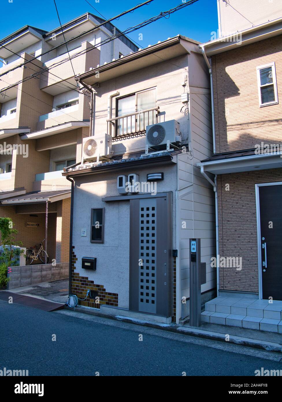 La vista in elevazione frontale di una stretta, molto piccola casa a schiera in un sobborgo di Kyoto, Giappone, illustrante la carenza di spazio di edificio in Giappone moderno. Foto Stock