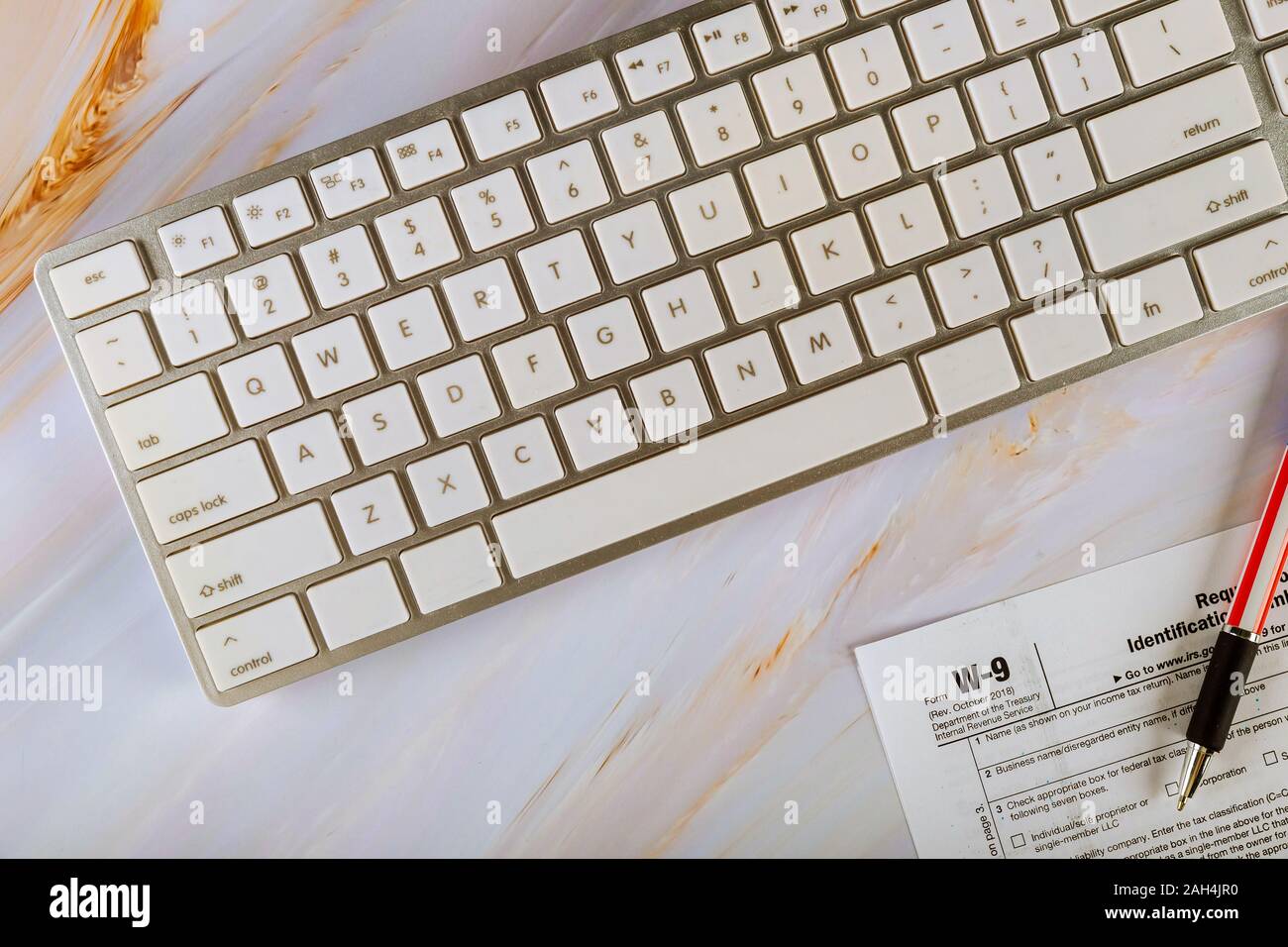 Applicazione di IRS Form W-9, richiesta di codice identificativo del contribuente la certificazione con la penna sulla tastiera di un computer Foto Stock