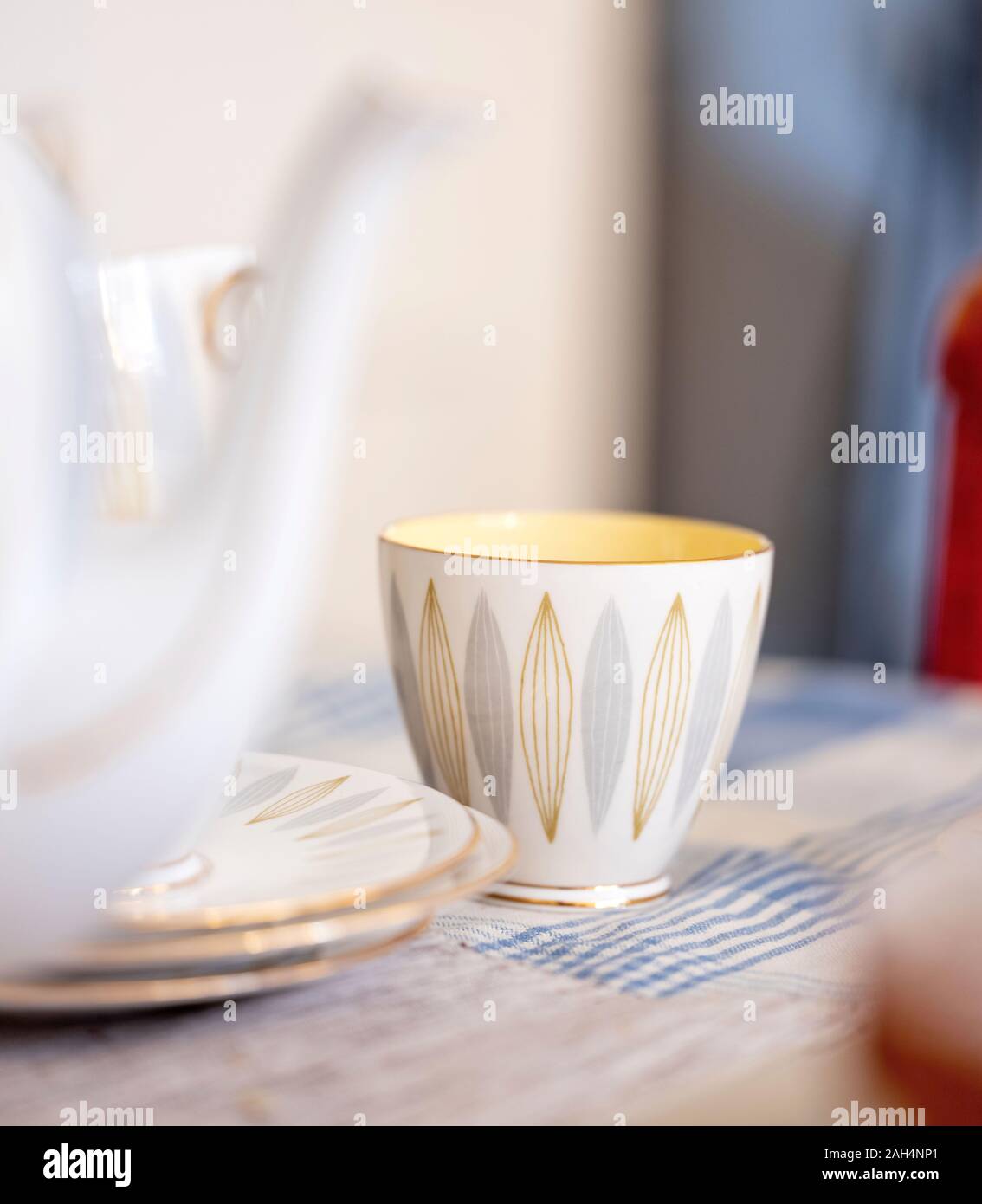 Una luce colorata vintage tazza da tè su un tavolo da cucina. Foto Stock