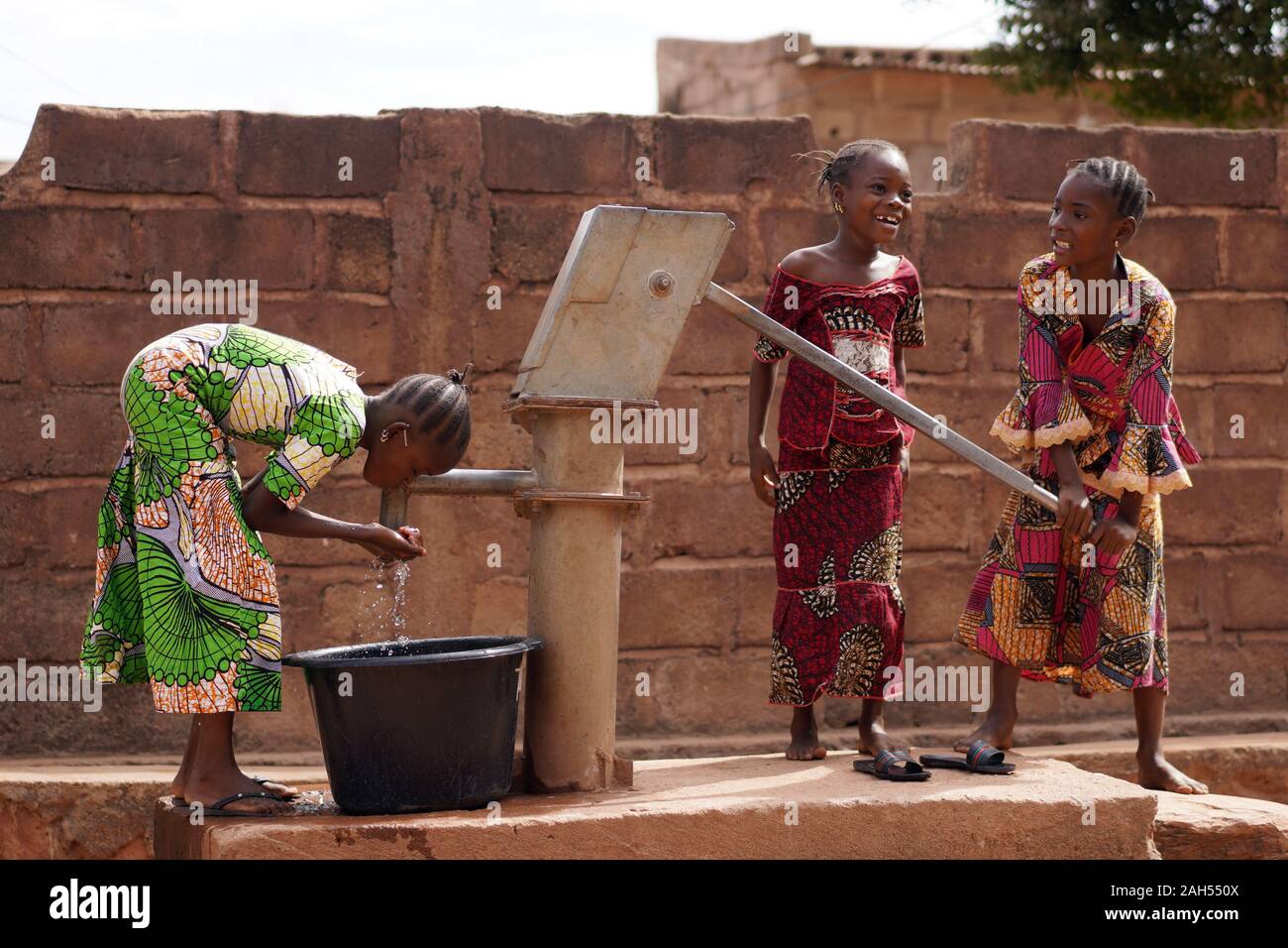 Ragazze Africane Occupate A Prendere Acqua Potabile Pulita E Fresca Foto Stock