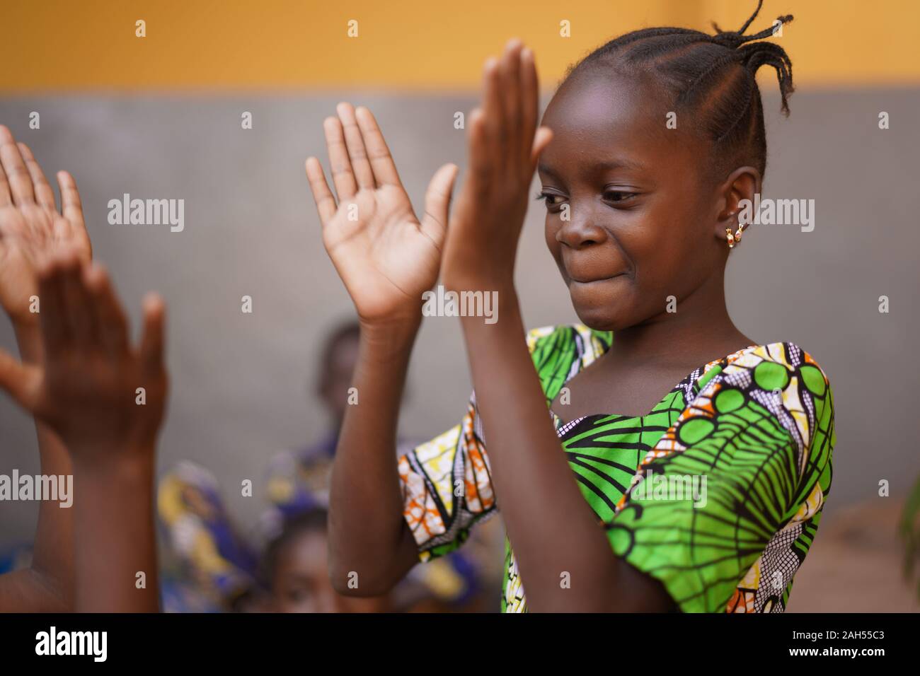 Giovane ragazza africana concentrandosi sulla sua mano battimani gioco Foto Stock