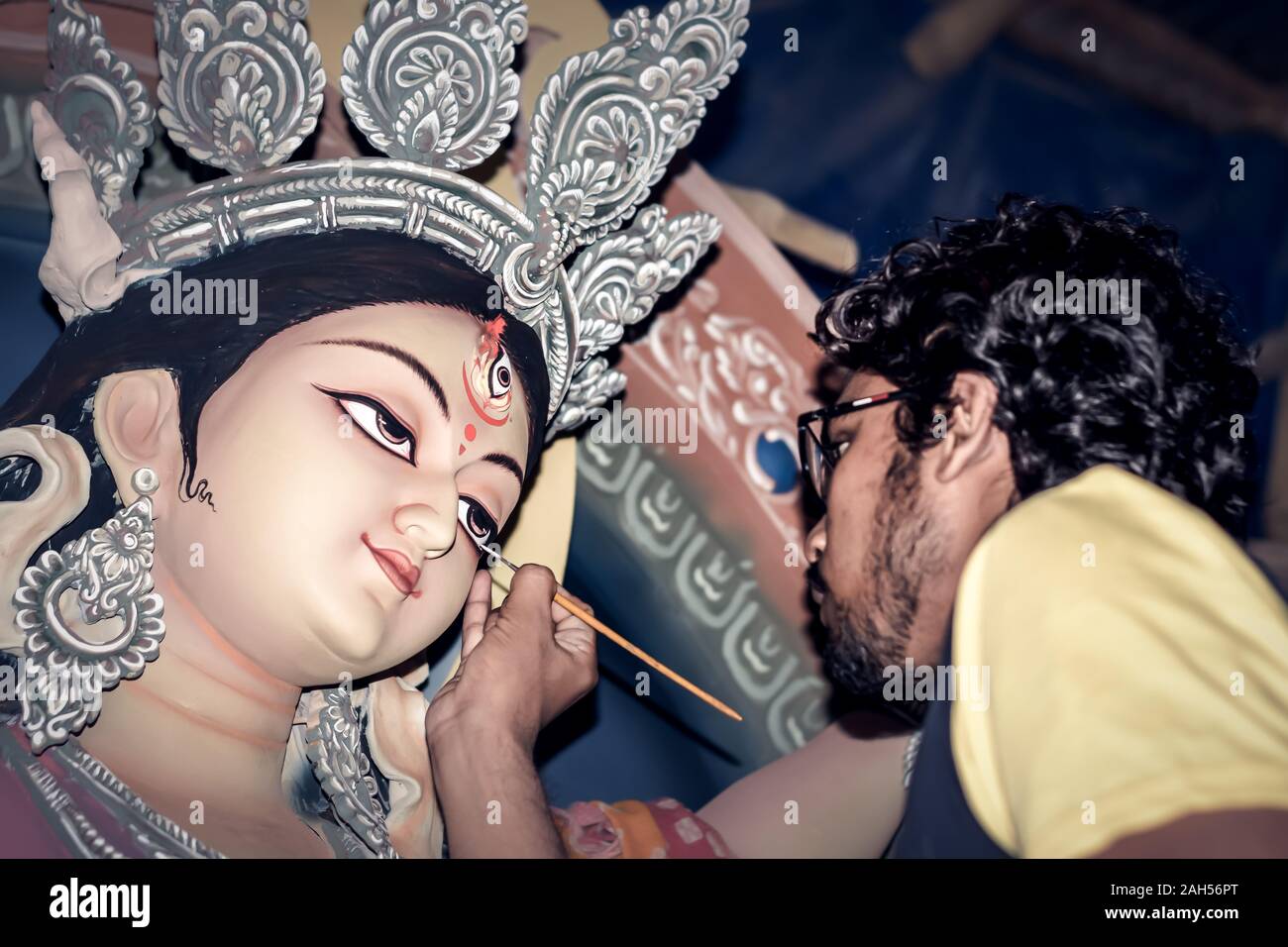 Pittura l'occhio su argilla idolo di dea Indù Durga. Un idolo del processo di produzione della ceramica artista a Kumartuli durante la Durga Puja Festival. Kolkata. Wes Foto Stock