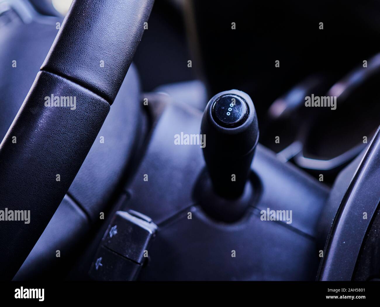 Vista la leva degli indicatori di direzione e una parte del volante nella parte anteriore interna di una automobile Foto Stock