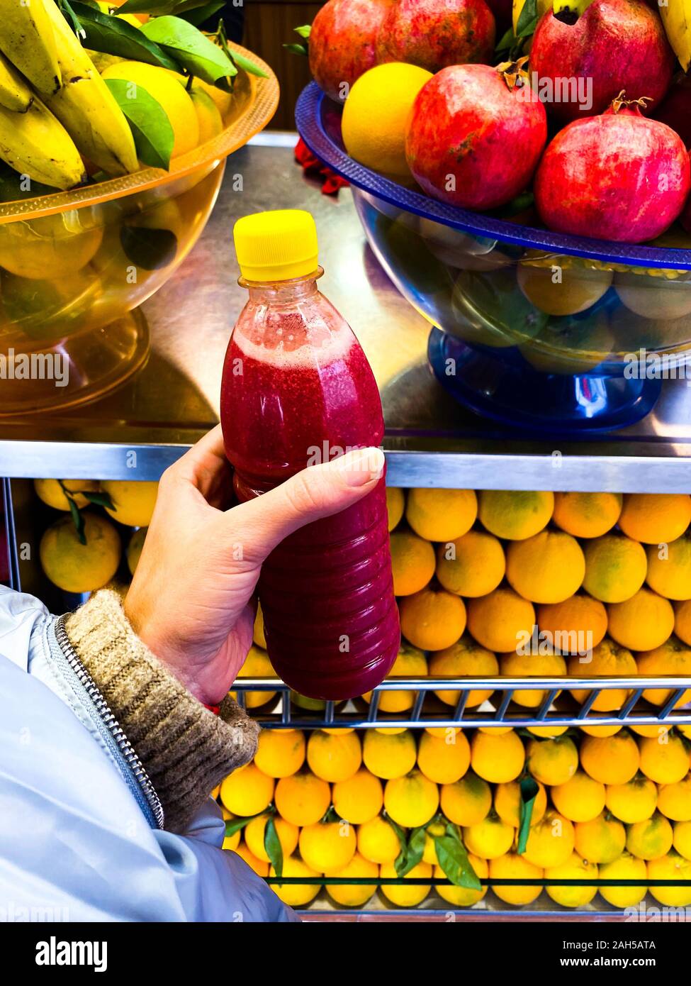 La bottiglia di plastica del succo di frutta in mano della ragazza. Uno stile di vita sano. Viaggi. Foto Stock