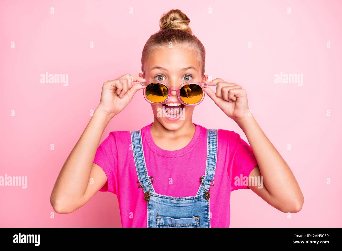 Close up foto di estatica bella carino funny girl guardando fuori della sua sunglass, urlando esultanza con holiday inizio isolato su rosa pastello colo Foto Stock