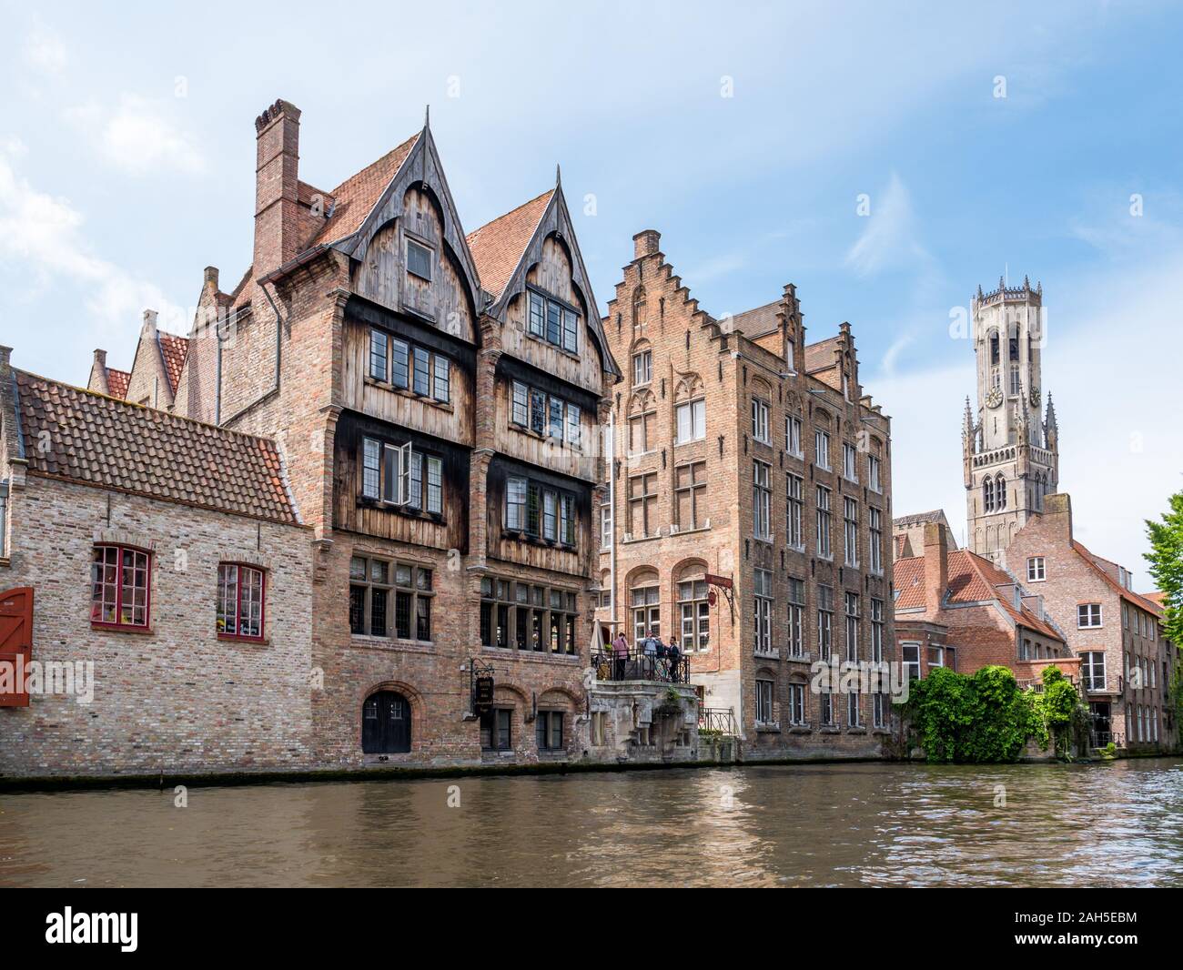 Kraanrei canal con edifici storici e torre campanaria nel centro storico di Bruges, Belgio Foto Stock