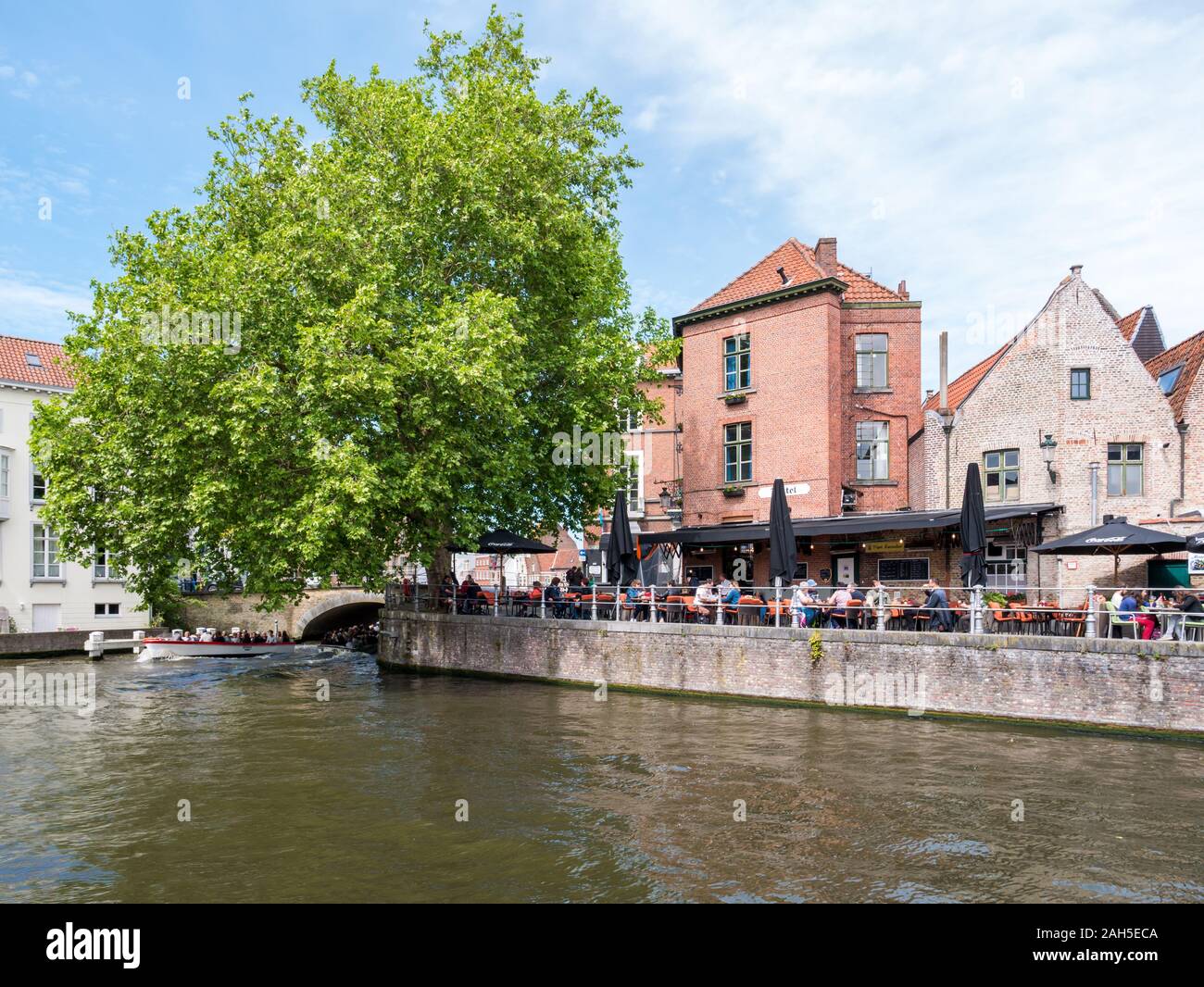 Predikherenrei con un ristorante esterno e del canale nel centro storico di Bruges, Belgio Foto Stock