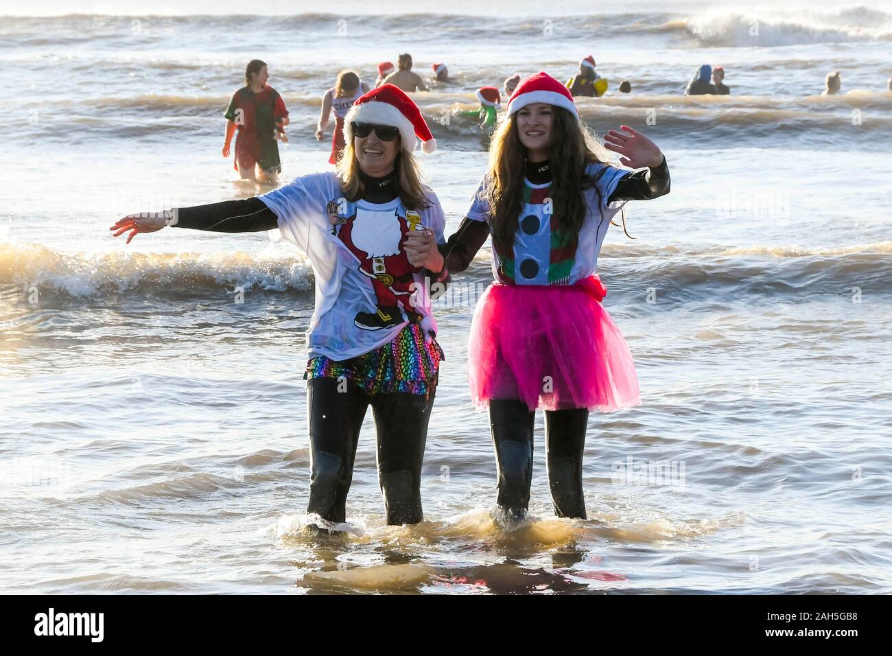 Charmouth, Dorset, Regno Unito. Il 25 dicembre 2019. Centinaia di festaioli di Fancy Dress prendere parte all'annuale del giorno di Natale nuotare in spiaggia Charmouth nel Dorset in aiuto della RNLI. Credito Foto: Graham Hunt/Alamy Live News Foto Stock