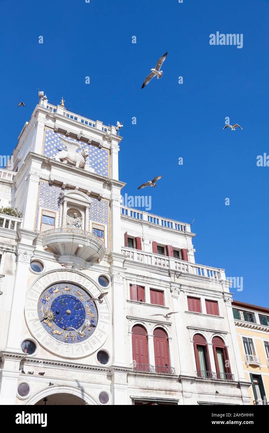 Torre dell'orologio di Piazza San Marco, Venezia, Veneto, Italia con la sua storica dello zodiaco astronomico orologio, leone veneziano e Madonna circondata dal mare di volo Foto Stock