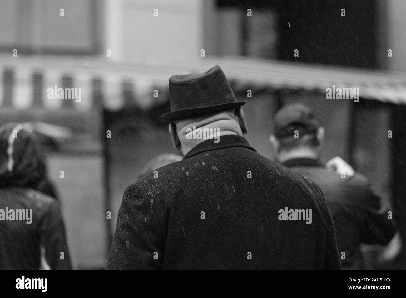Uomo di mezza età con collo hefty e trilby hat in un giorno di pioggia Foto Stock