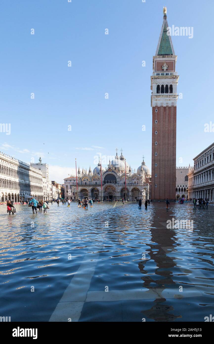 Acqua Alta inondazioni durante l estrema alta marea Piazza San Marco, Venezia, Italia. St Marks Campanile riflessa nell'acqua di inondazione Foto Stock