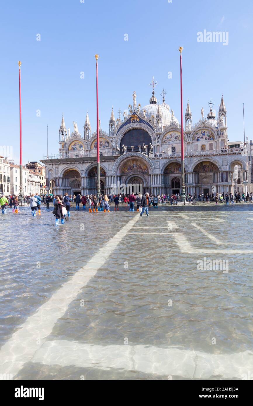 Acqua Alta inondazioni durante l estrema alta marea Piazza San Marco, Venezia, Italia. Visualizza in basso la piazza per la Basilica di San Marco con acqua di inondazione e tourist Foto Stock