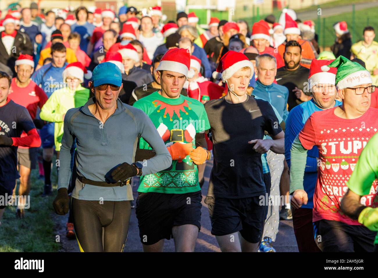 Chippenham, Wiltshire, Regno Unito. 25th dicembre 2019. I corridori sono raffigurati mentre prendono parte ad un parkrun 5km di Natale di mattina presto in Monkton Park, Chippenham, Wiltshire. 400-500 persone hanno partecipato all'evento con molti vestirsi in abito elegante. Credito: Lynchpics/Alamy Live News Foto Stock