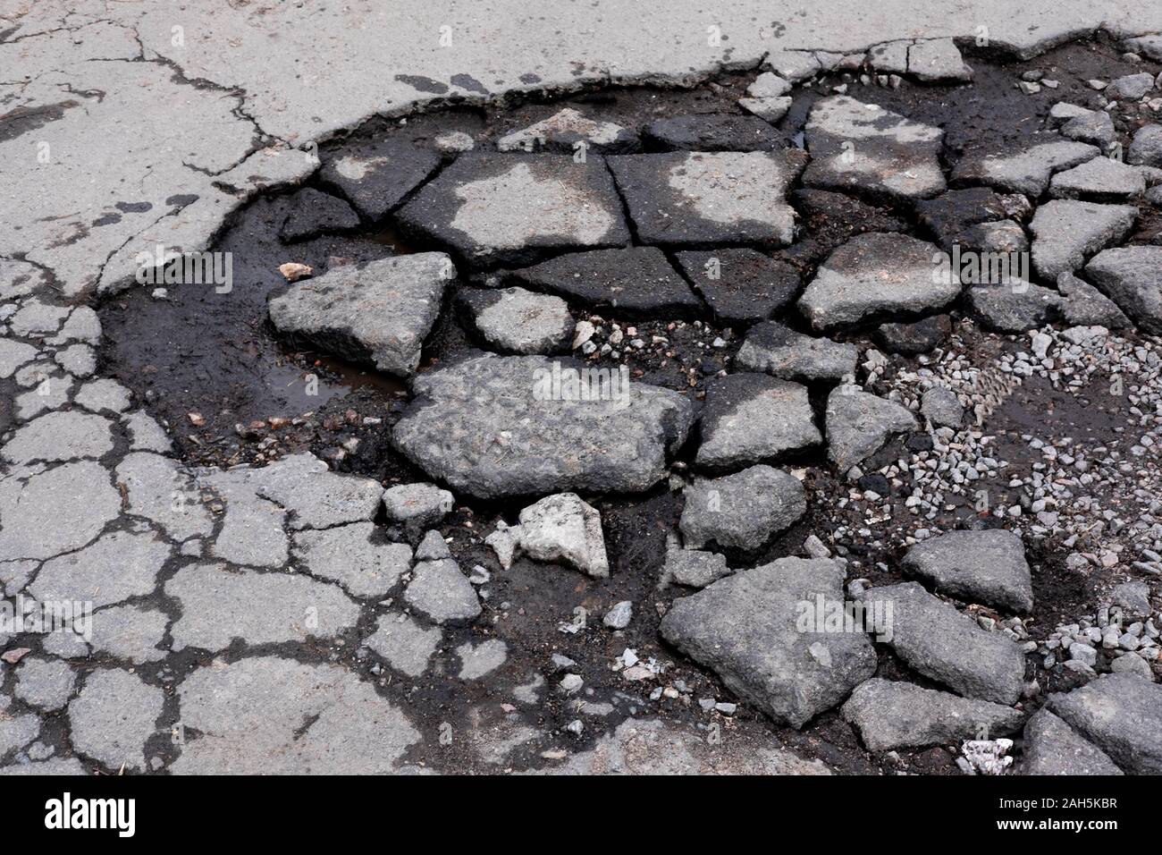 Strade dissestate. Riparare strada asfaltata. Distruzione della carreggiata. La distruzione di strade Foto Stock