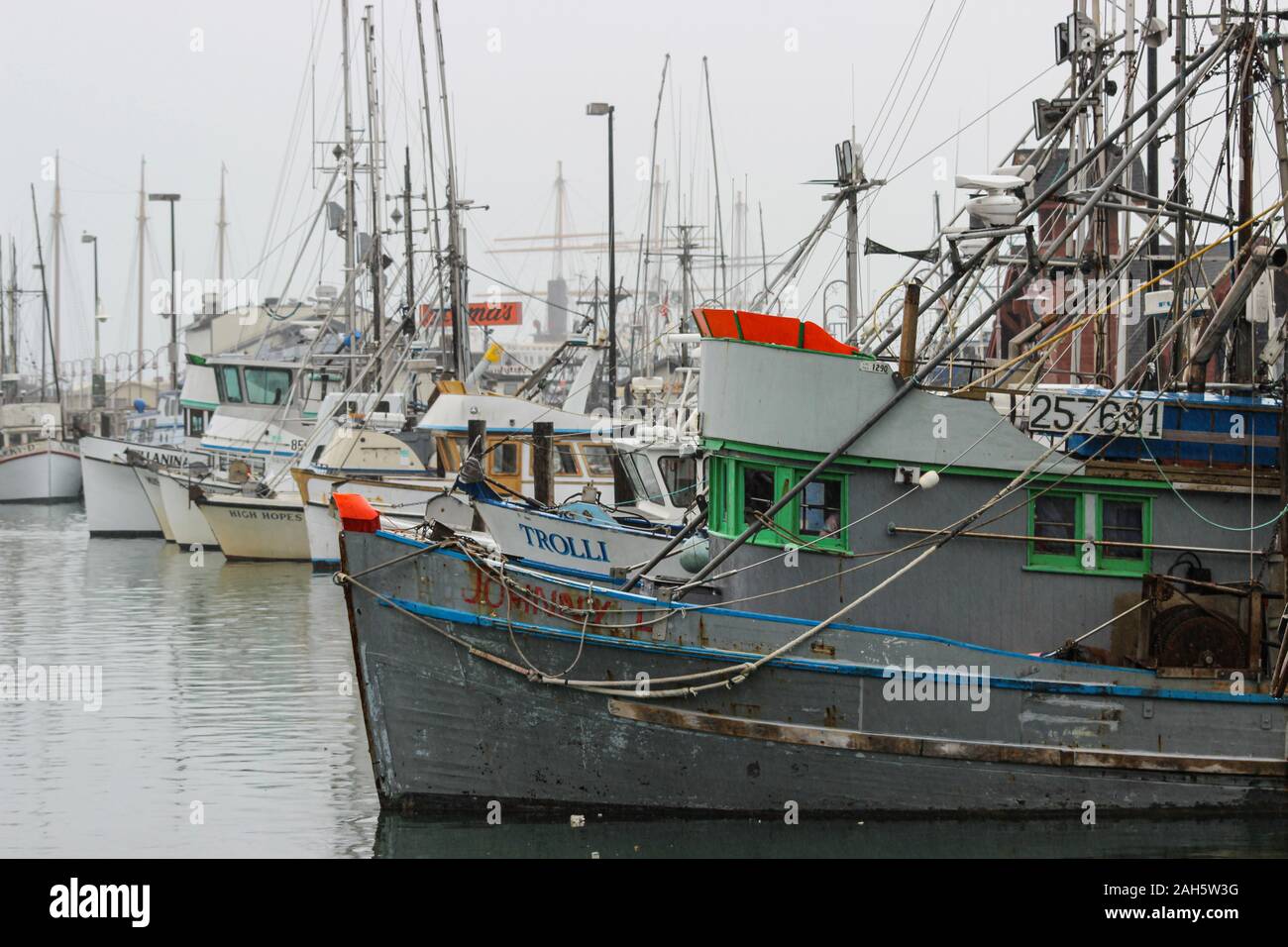 Barche da pesca e il granchio barche ormeggiate al Pontile del Pescatore in una piovosa e nebbioso giorno di San Francisco, Stati Uniti d'America Foto Stock