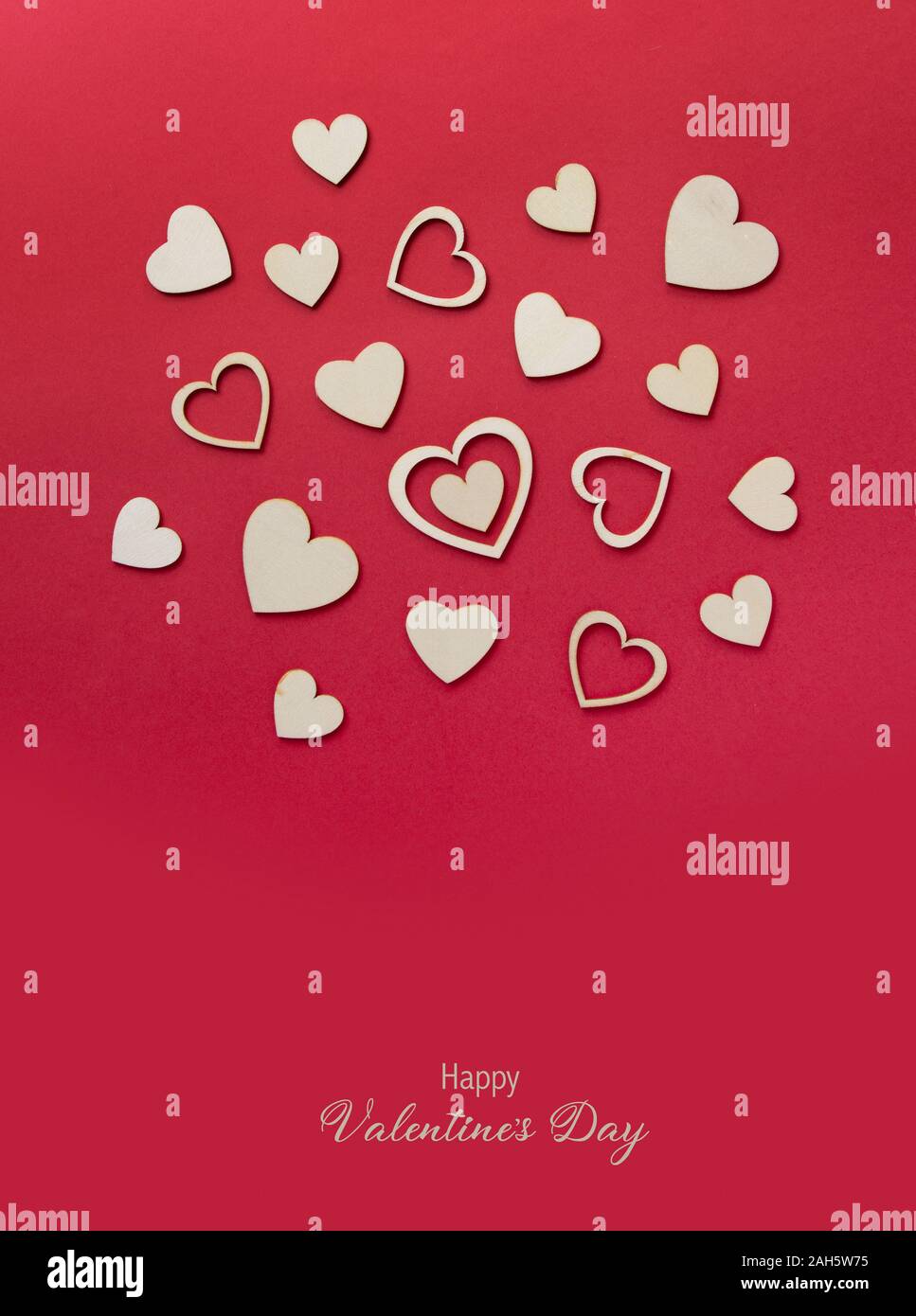 Cuori di legno sul rosso pastello sfondo. Sfondo astratto con le forme di legno. Invito di San Valentino Foto Stock