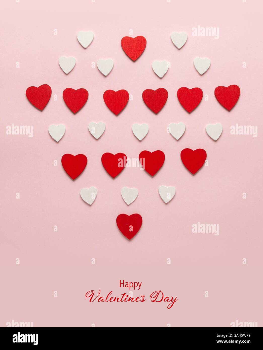 Red cuori di legno sul rosa pastello sfondo. Sfondo astratto con legno tagliare le forme. Valentino, biglietti di auguri, invito celebrazione concep Foto Stock