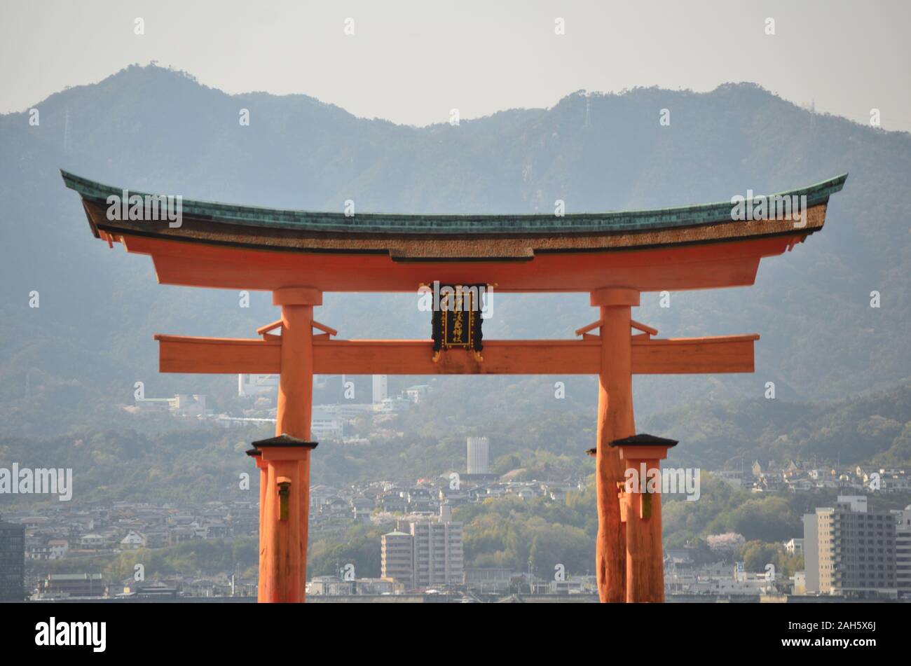 Dettaglio del grande Torii di Miyajima sullo sfondo delle montagne Foto Stock