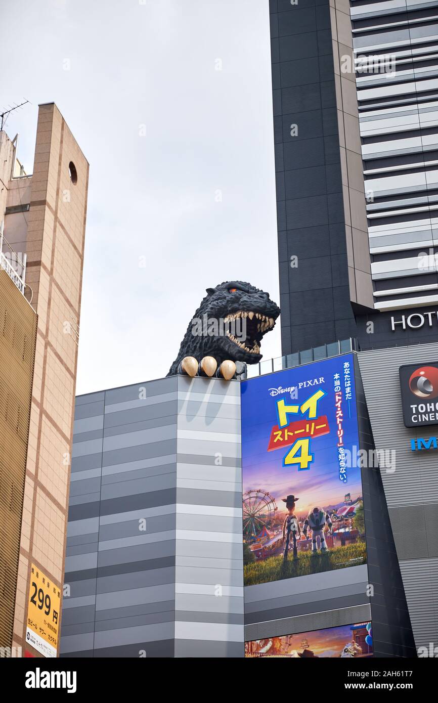 Godzilla di sbirciare da dietro un giapponese di Toy Story 4 billboard; Shinjuku, Tokyo, Giappone Foto Stock