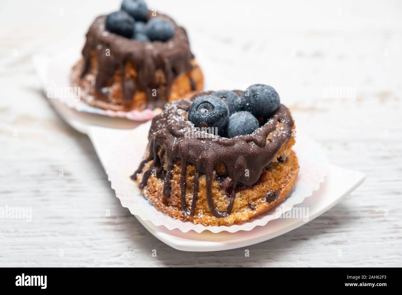 Pane appena sfornato muffin ai mirtilli con topping di cioccolato Foto Stock