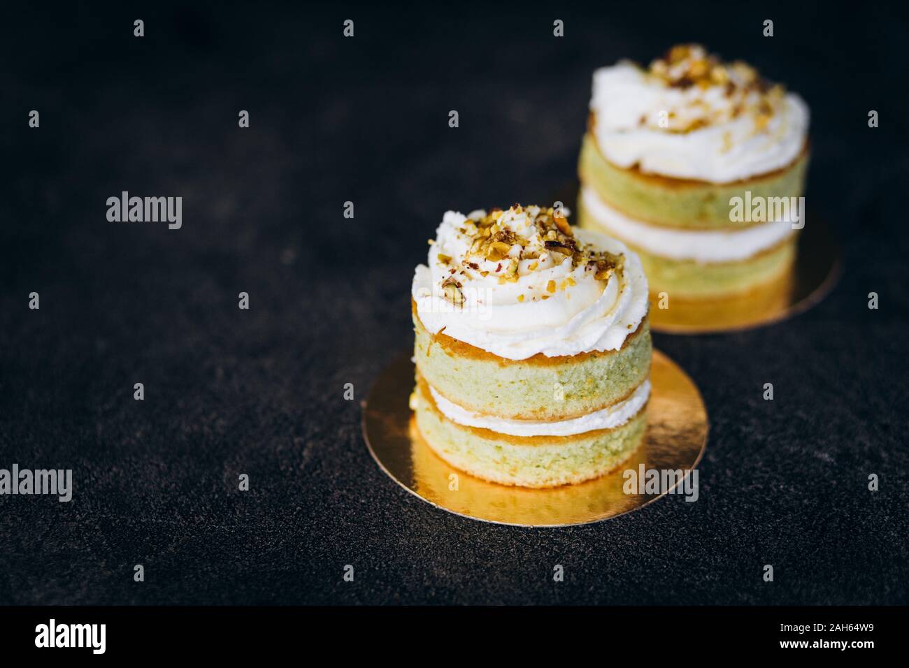 Torte con crema bianca e su uno sfondo nero. Cottura e dolci. Foto Stock