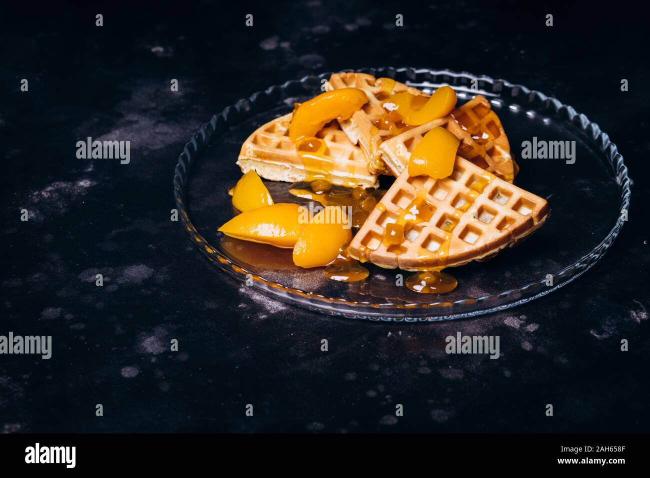 Cialde con pesche per la colazione su uno sfondo nero. Foto Stock