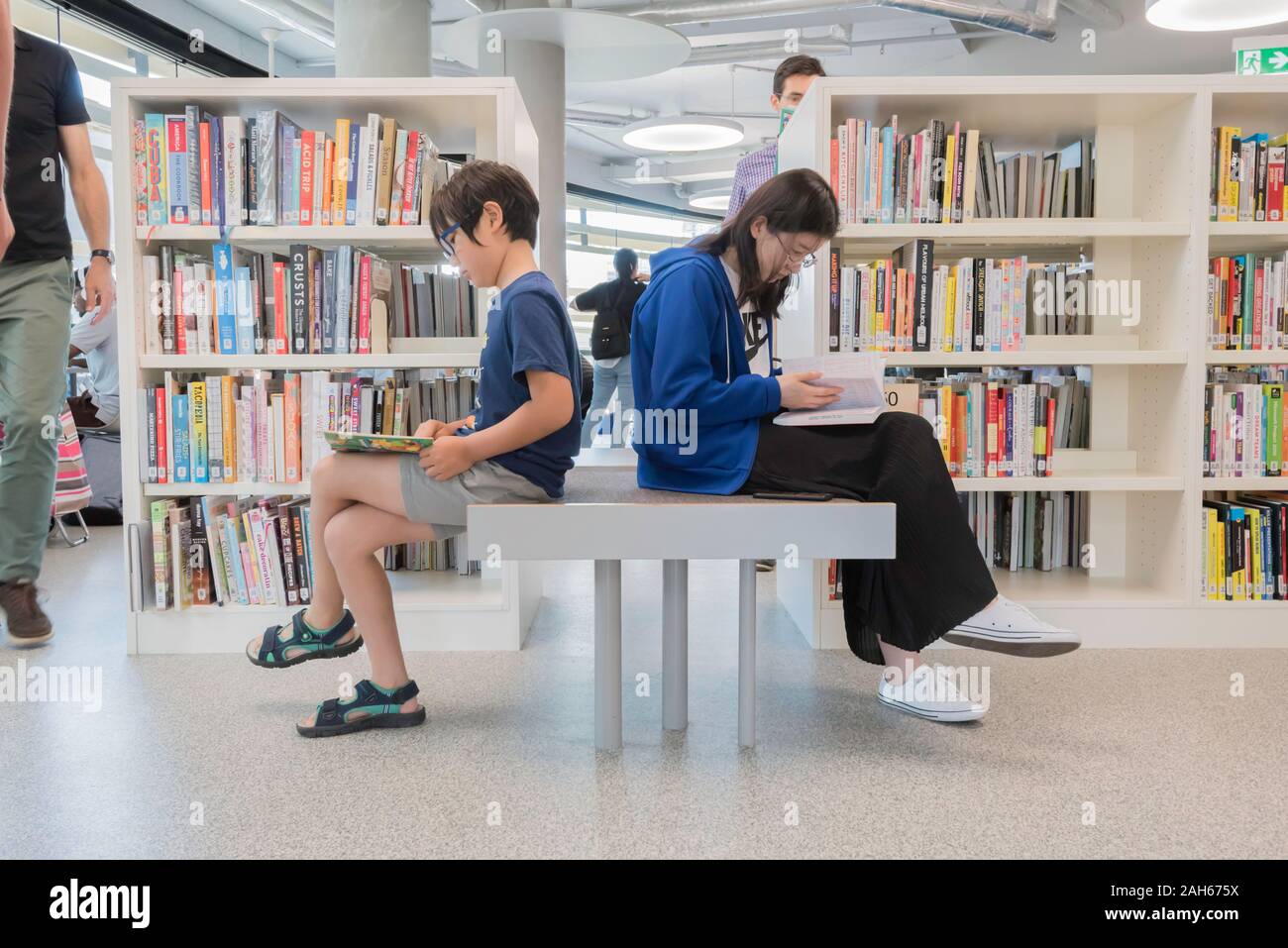 10 NOV 2019: bambini e persone adulte la lettura all'apertura del nuovo edificio della Borsa e la città di Sydney Libreria nel Darling Square, Sydney Foto Stock