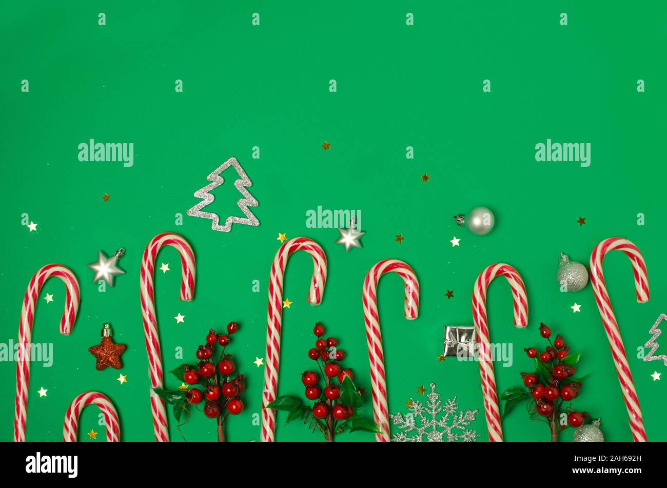 Composizione di natale su sfondo verde. Xmas frame con candy canes, bacche rosse. Vista superiore, piatto laici. Foto Stock