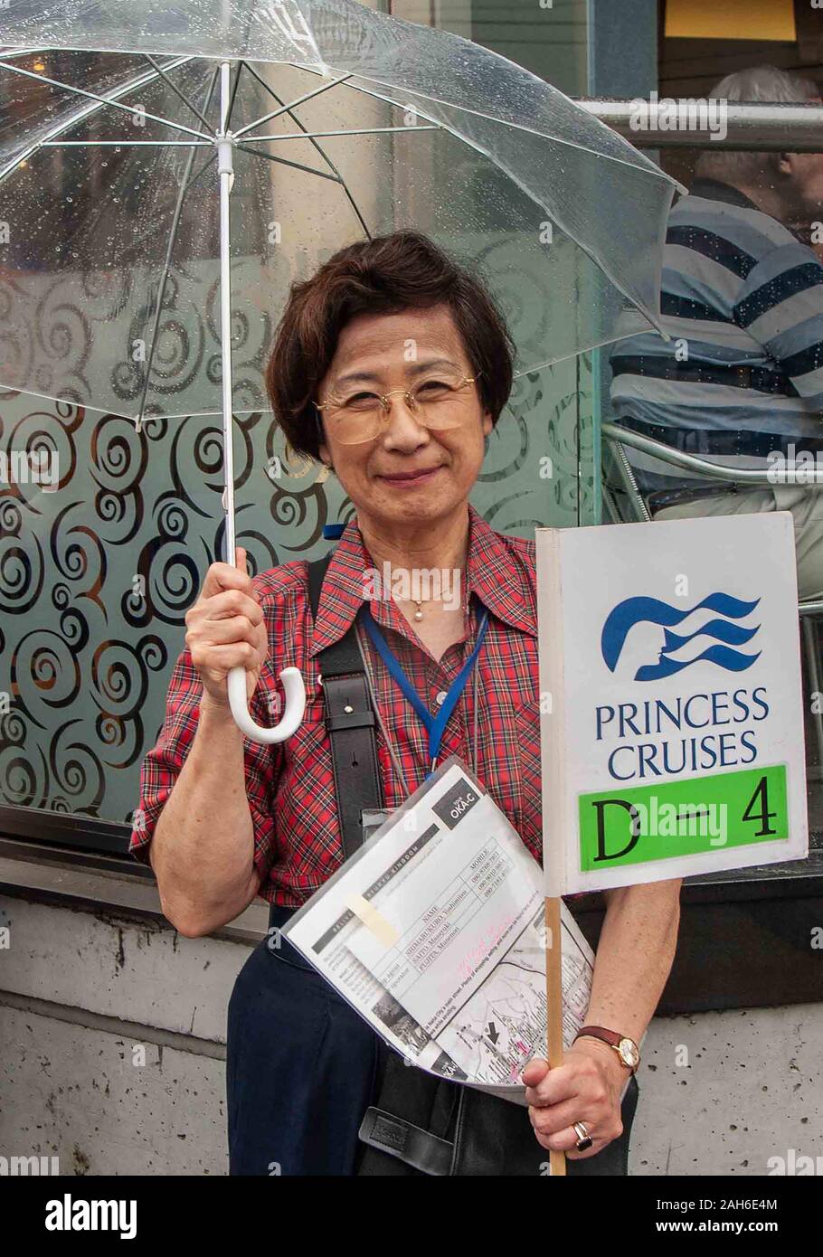 Naha, Okinawa, isole Ryukyu. 1 Nov, 2006. Ritratto di una donna di Okinawa guida turistica portando un ombrello e una mappa e la nave di crociera segno di identificazione a Naha, capitale della Prefettura di Okinawa e una destinazione preferita dai turisti. Naha è il centro politico ed economico di Okinawa, dominato dal turismo, retail e industrie dei servizi. Credito: Arnold Drapkin/ZUMA filo/Alamy Live News Foto Stock