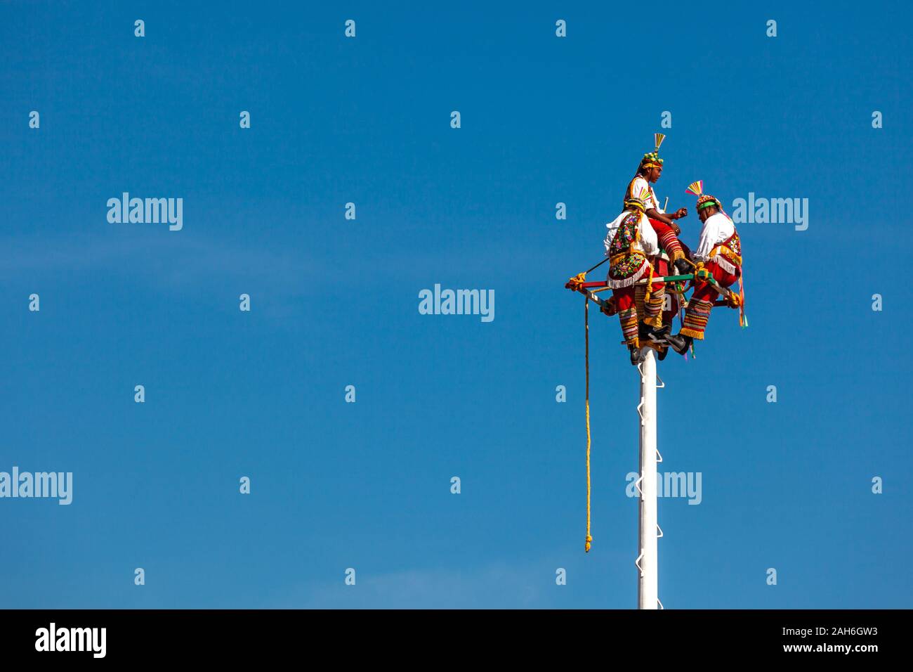 Teotihuacan, Messico - 25 novembre 2019: tre uomini in costumi nazionali sono seduti sulla sommità di un pilastro. Tenetevi pronti per una danza rituale volador Foto Stock