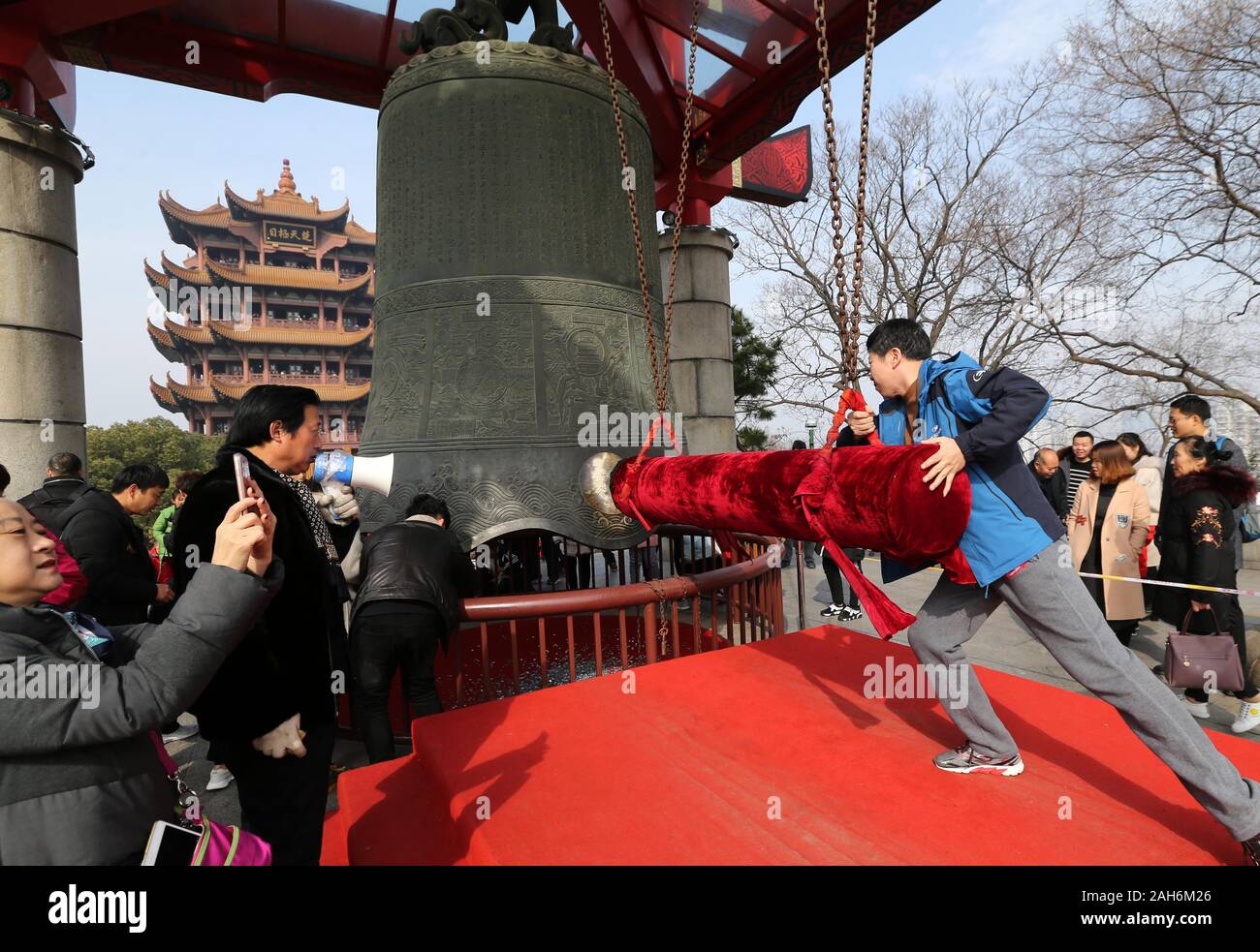 (191226) -- PECHINO, Dic 26, 2019 (Xinhua) -- Un visitatore colpisce la grande campana presso il Parco Huanghelou a Wuhan, Cina centrale della provincia di Hubei, Febbraio 5, 2019. Parchi urbani in Cina offre un semplice luogo per le persone a rilassarsi e distendersi. Inoltre, la Cina parchi urbani includono più di meno impatto di attrezzature e modi di divertimento per i giovani e vecchi. Con la brezza soffia e barche galleggianti in parchi, la gente è piaciuto ballare, cantare e folklore delle prestazioni da anni Cinquanta agli Anni Novanta. Oggi le persone hanno più scelte di attività nei parchi, come il fashion show di anziani la gente del posto e i l Foto Stock