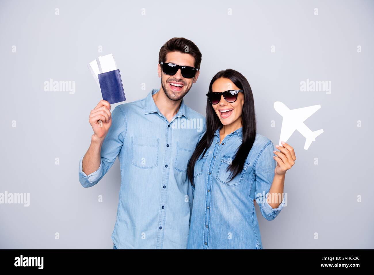 Foto del ragazzo divertente e lady holding biglietti aerei consulenza acquista tour a caldo a prezzi bassi, indossare abiti casual isolato grigio colore di sfondo Foto Stock