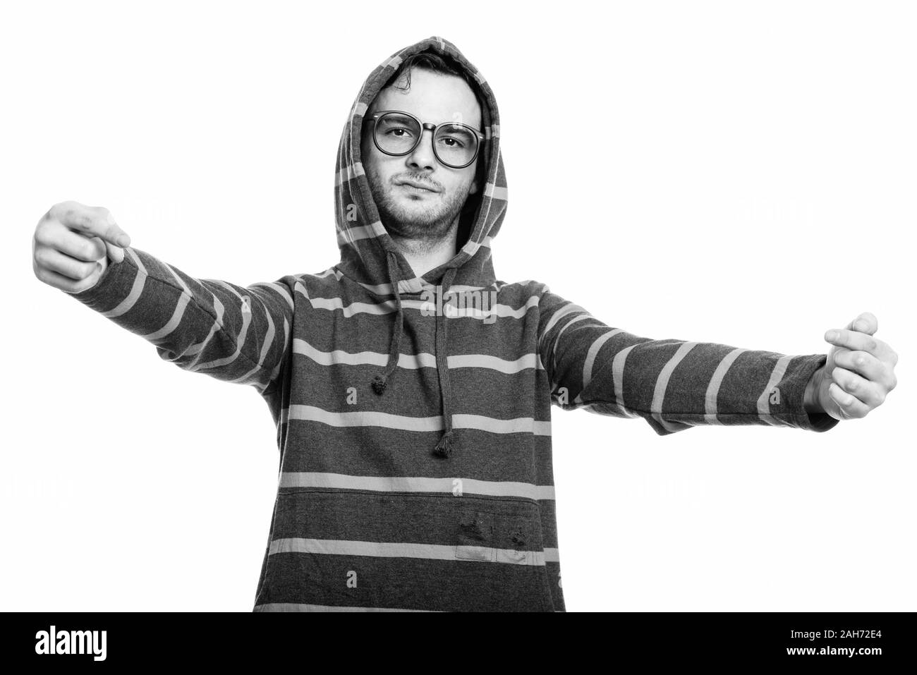 Studio shot del giovane uomo che indossa hoodie mentre puntando entrambe le dita a se stesso Foto Stock