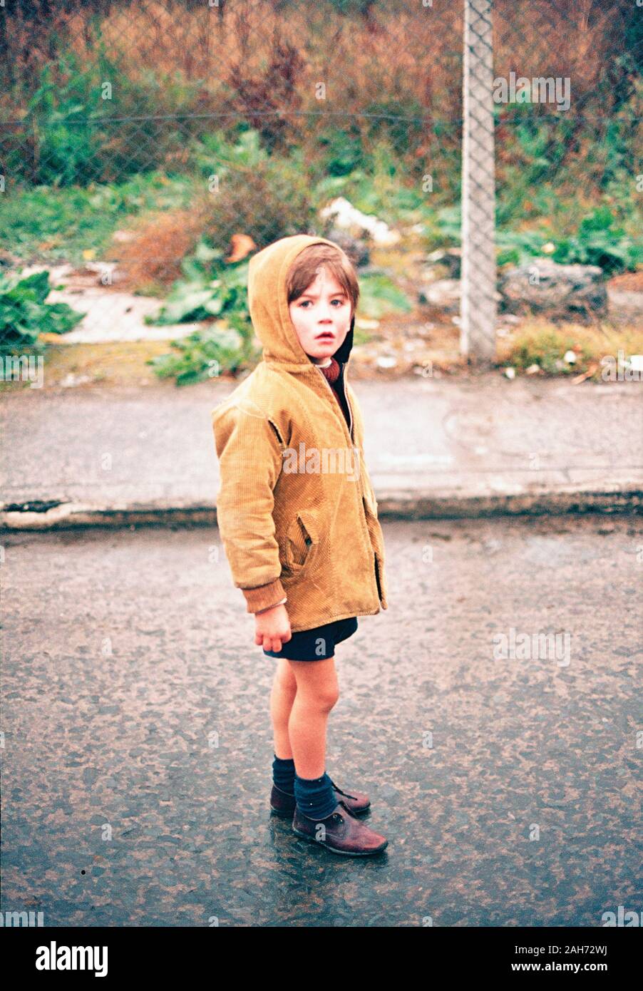 Un bambino che indossa una giacca con cappuccio e pantaloni corti nel  centro cittadino di Belfast durante i guai del 70s, Irlanda del Nord Foto  stock - Alamy