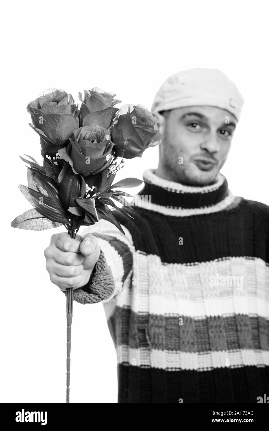 Studio shot del giovane uomo dando rose rosse con focus su rose rosse Foto Stock