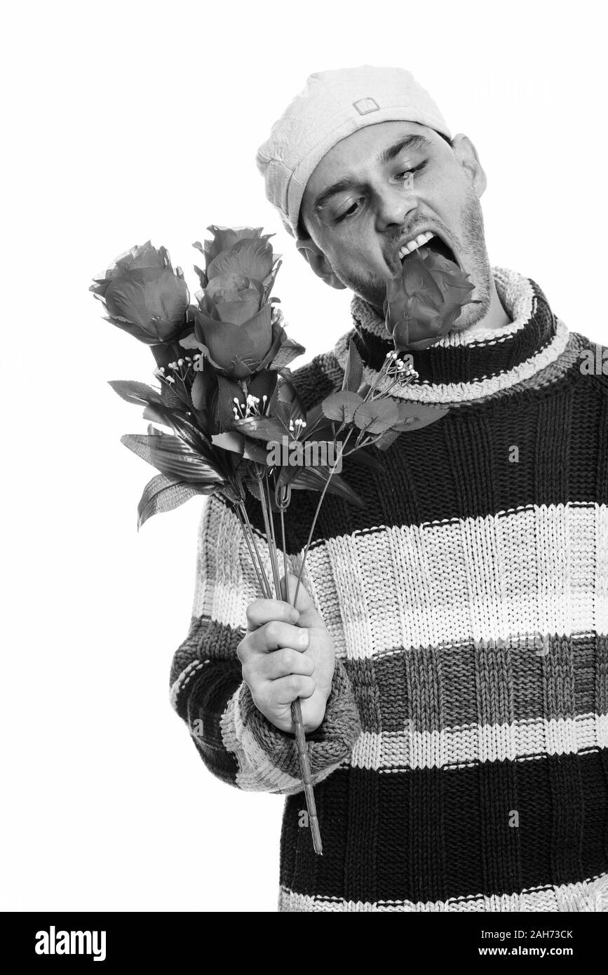 Studio shot del giovane uomo mangiare rose rosse Foto Stock