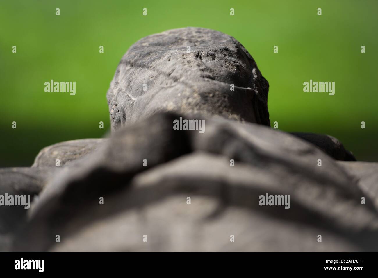 Primo piano di un antico sarcofago scozzese in marmo contro a. sfondo verde bokeh Foto Stock