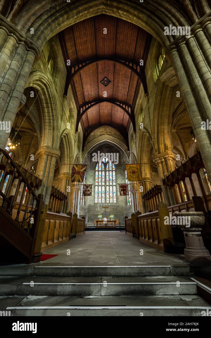 Ampio angolo dell'interno di una cattedrale gotica scozzese, con una volta in legno e vetrate colorate Foto Stock
