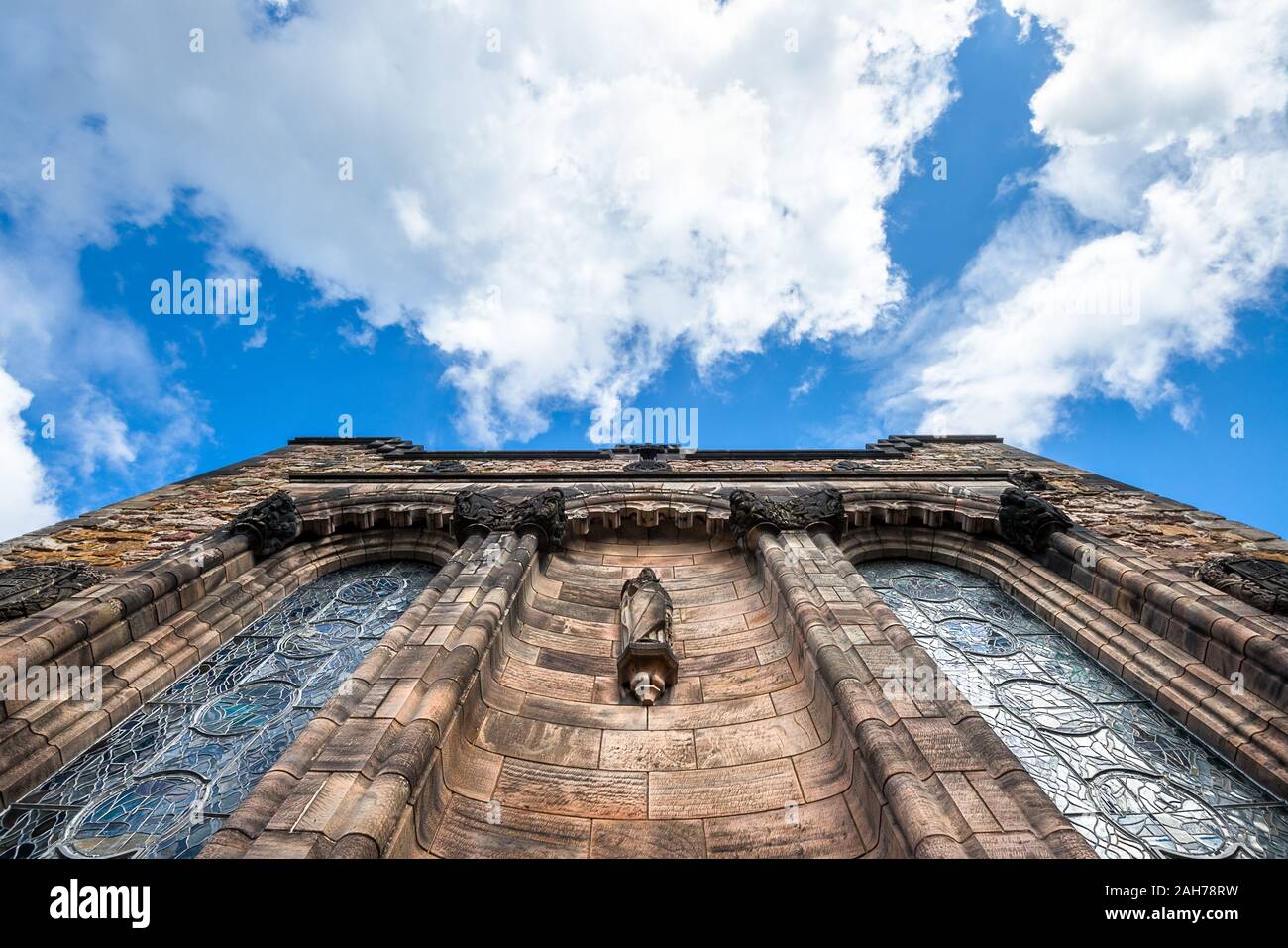 Immagine simmetrica della facciata in marmo di un antico castello, contro un cielo blu con nuvole soffici Foto Stock