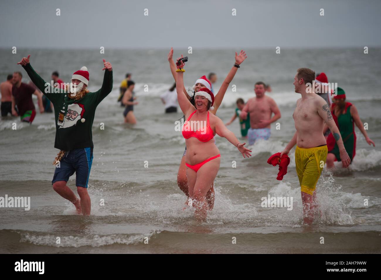 Tynemouth, Inghilterra, 26 dicembre 2019. I partecipanti di lasciare il Mare del Nord durante il Boxing Day Dip che è un evento annuale organizzato dal Mare del Nord volontario bagnini sul Tynemouth Longsands. Foto Stock