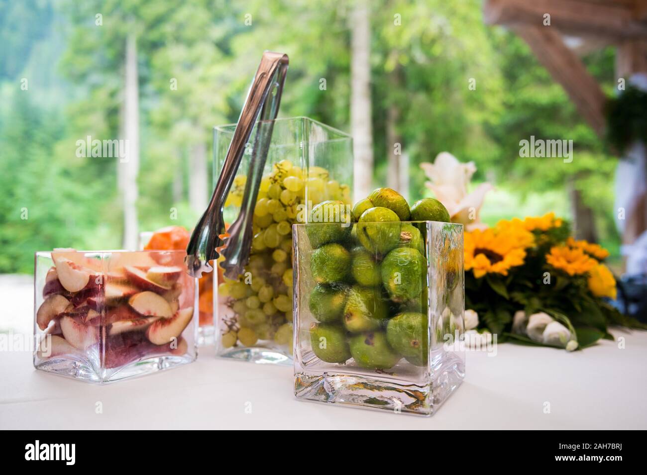 Primo piano di coppe quadrate di cristallo di frutta contro a. sfondo verde bokeh Foto Stock