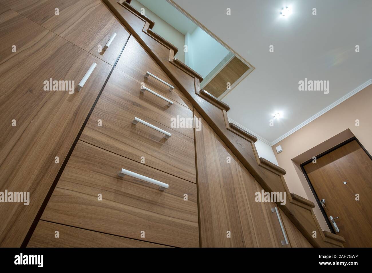 La moderna architettura di interni di lusso con corridoio con lucida scale in legno in multi-storey house. Costruito su misura per armadi di estrazione su scivola in slot und Foto Stock