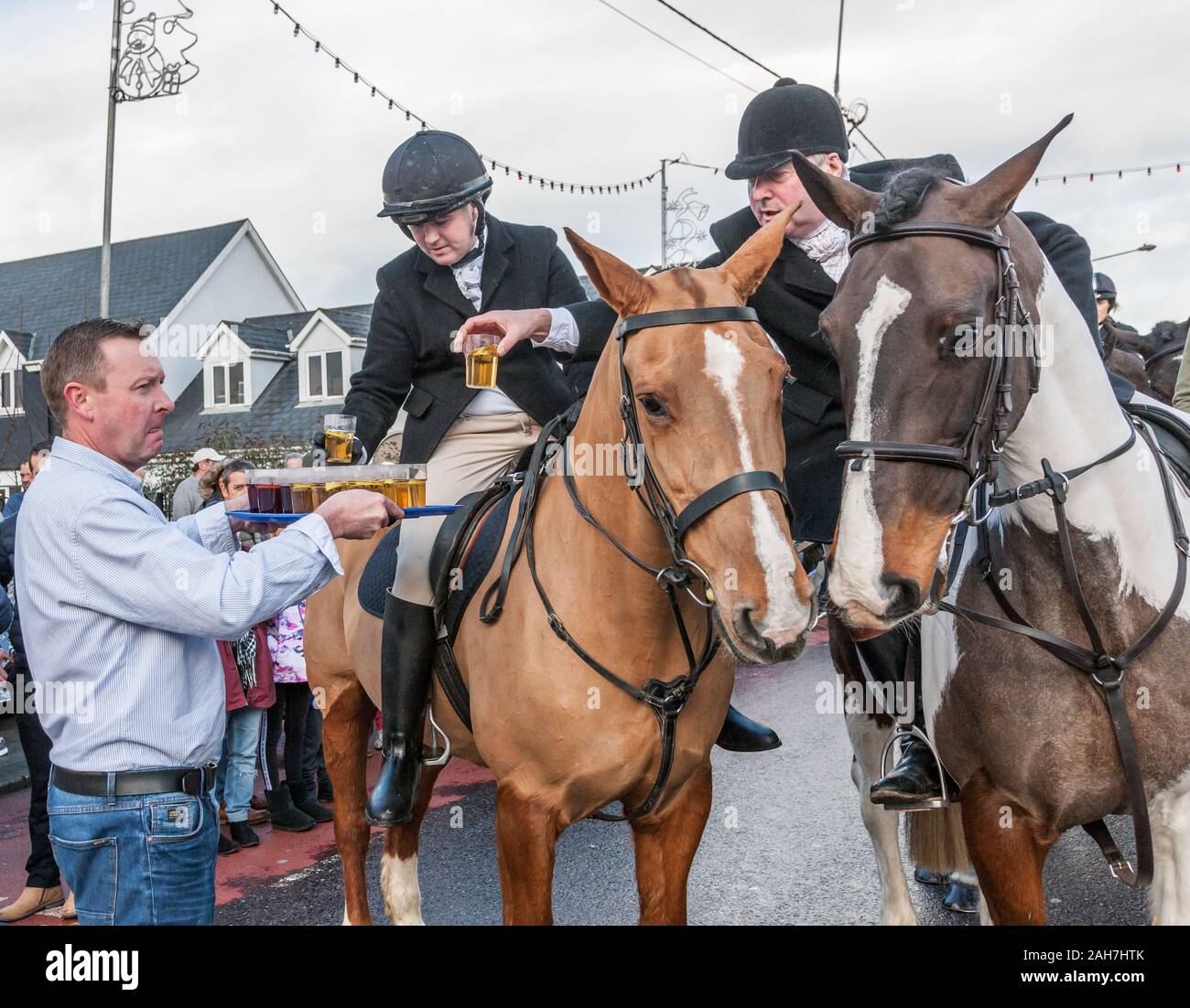 Carrigaline, Cork, Irlanda. 26 dicembre, 2019. Bar keeper Brendan Morrissey di Rosies Bar offre Toddies caldi ai membri del sud Unione Hunt prima dell'inizio della tradizionale il giorno di Santo Stefano, caccia su Main Street, Carrigaline, Co. Cork, Irlanda. - Credito; David Creedon / Alamy Live News Foto Stock