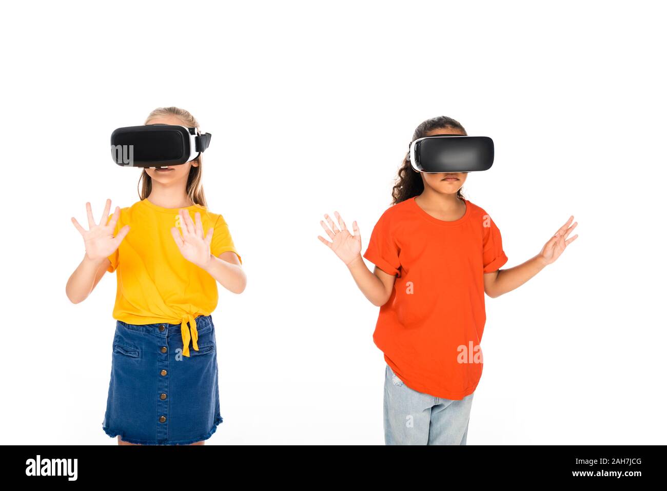 Due simpatici amici multiculturale utilizzando la realtà virtuale auricolari isolato su bianco Foto Stock