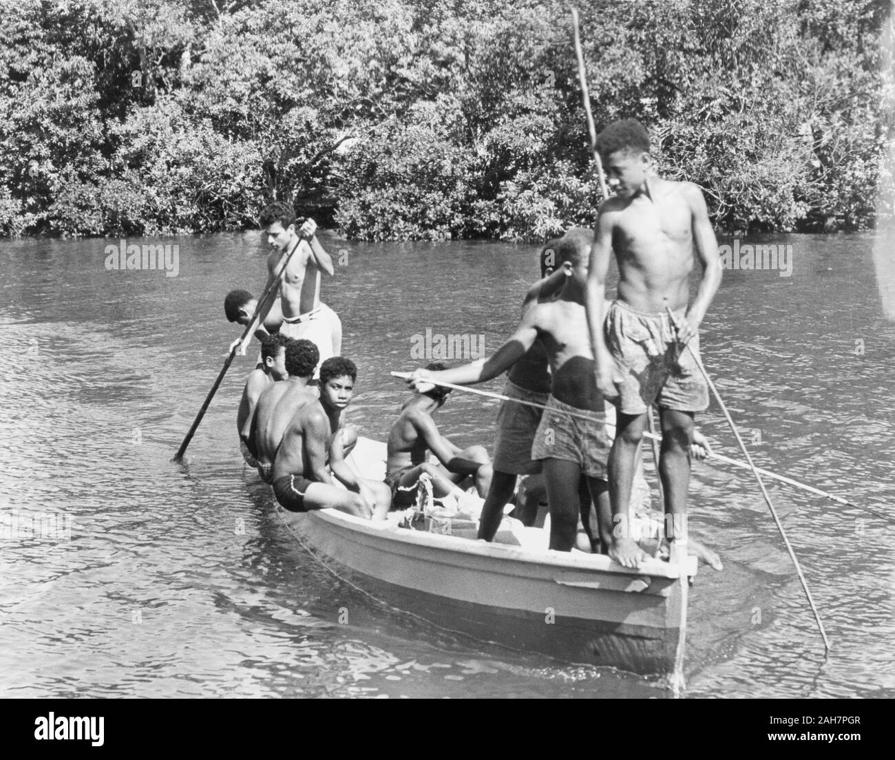 Fiji, i ragazzi in una canoa, FijiA gruppo di ragazzi in pantaloncini corti di rilassarsi al sole come un pilota in canoa lungo un fiume. La didascalia recita: Boys at play - Levuka - nell'isola di Ovalau, 1965. 2005/010/1/14/76. Foto Stock